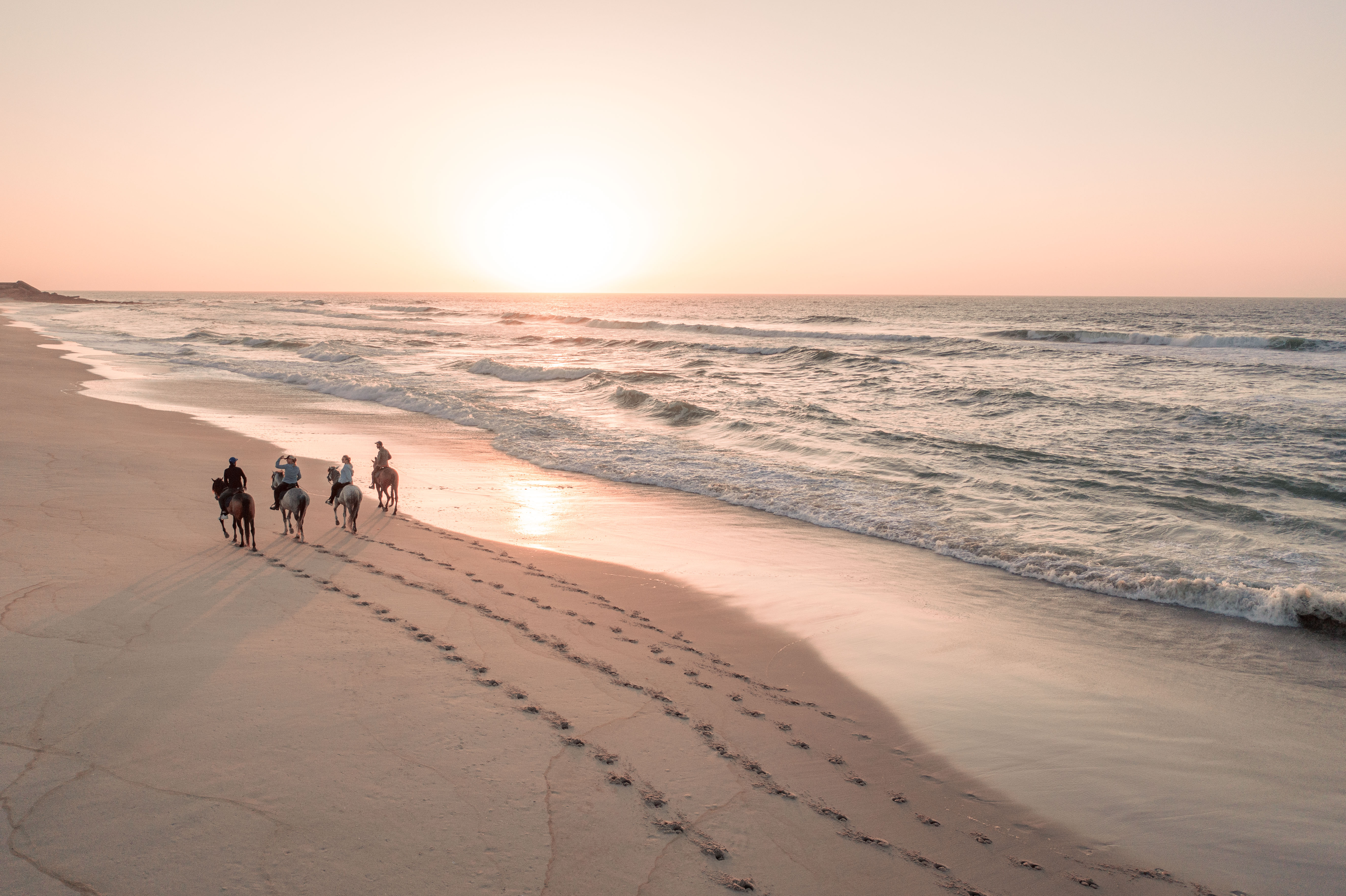 Cavaliers au coucher du soleil dans les dunes de Dakhla, Maroc