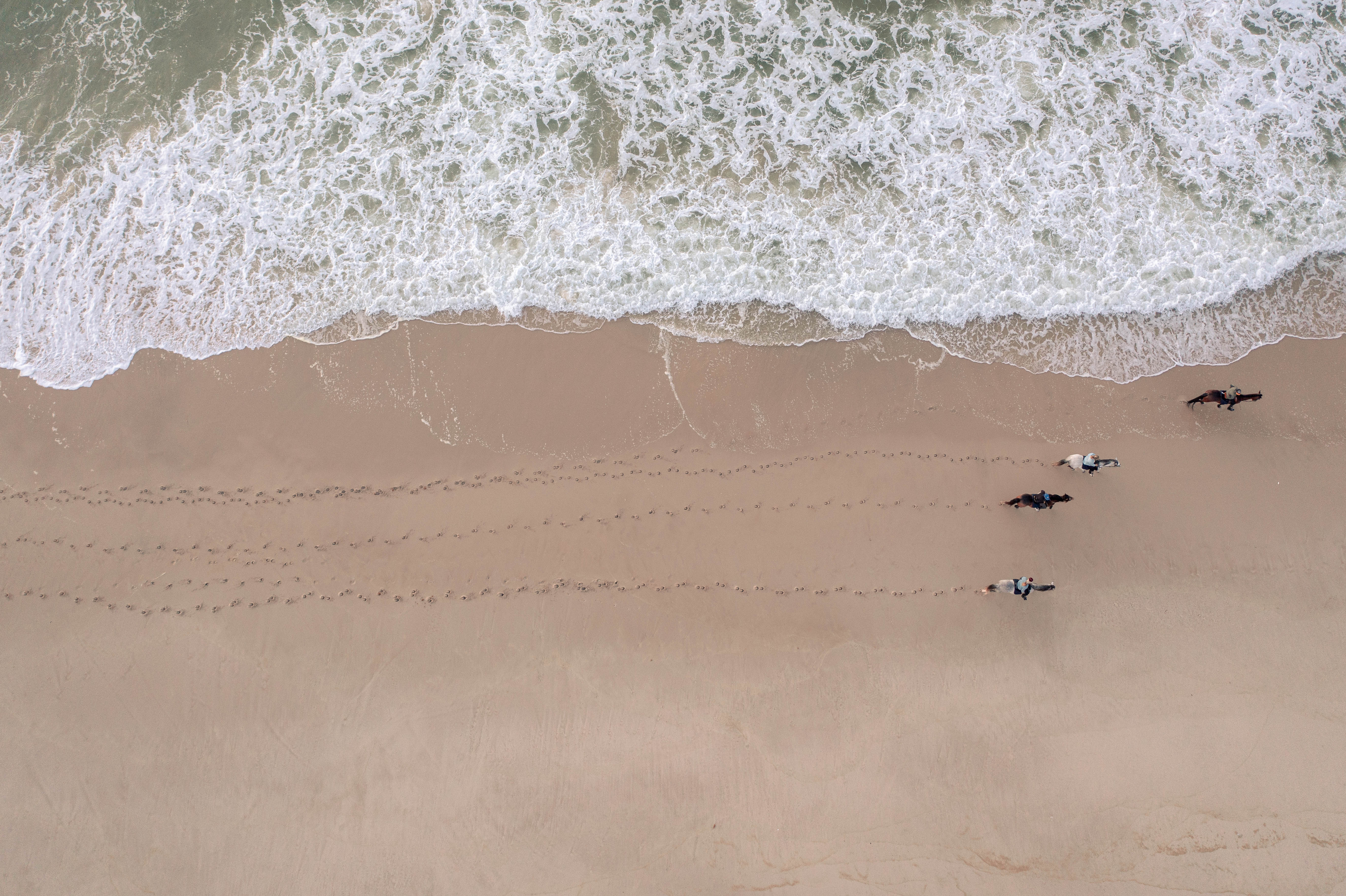 Cavaliers profitant du coucher de soleil sur la plage de Dakhla, vue zénithal